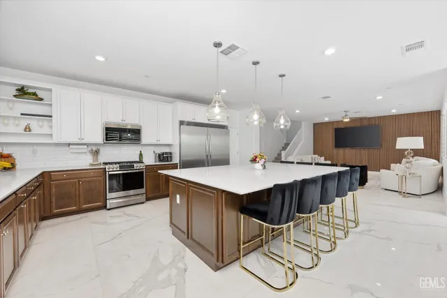 a kitchen with stainless steel appliances kitchen island granite countertop a sink and cabinets