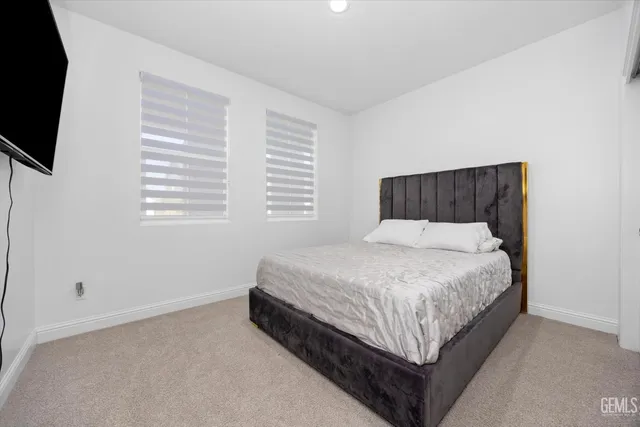 a bed sitting in a bedroom next to a window