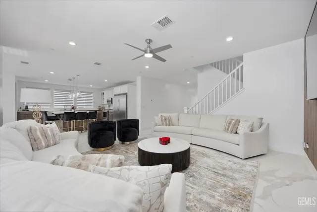 a living room with lots of furniture and white kitchen