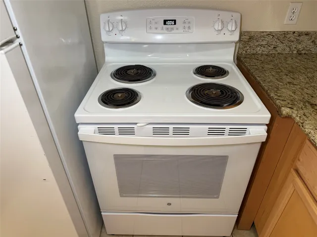 a view of a livingroom with a chandelier fan and wooden floor