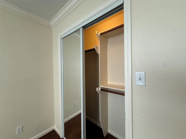 a room with a stove and white cabinets