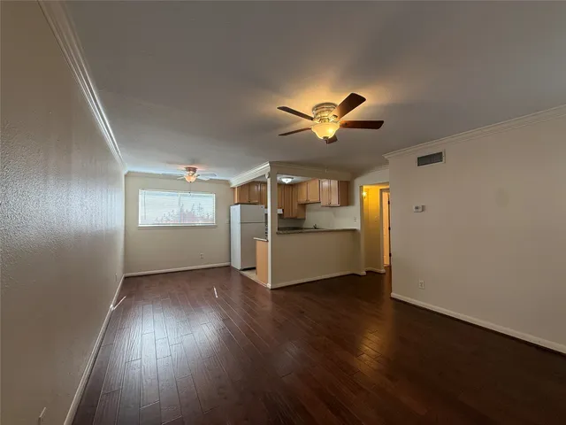 a view of a livingroom with wooden floor and a ceiling fan