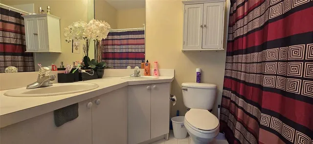 a bathroom with a sink a toilet and mirror