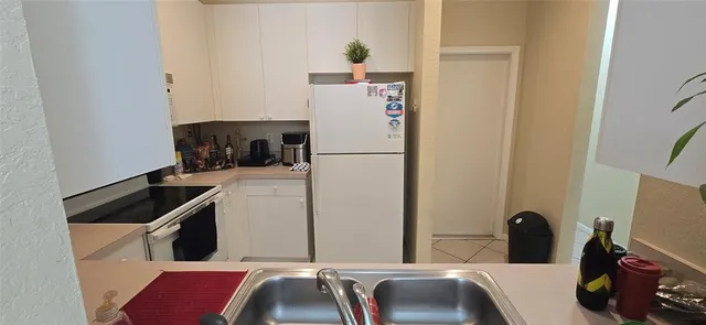 a kitchen with a refrigerator and a sink