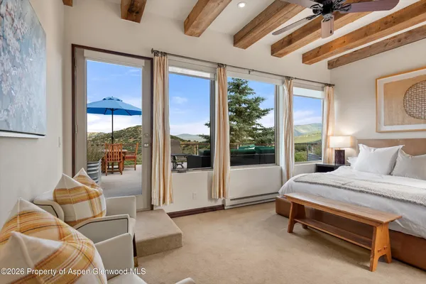 a bedroom with furniture and a large window