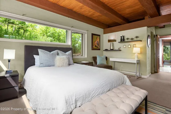 a spacious bedroom with a bed and a large window