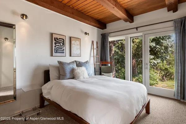 a large bed sitting in a bedroom next to a window