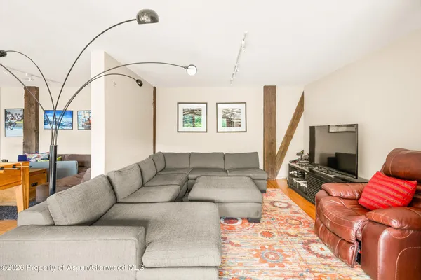a living room with furniture a flat screen tv and a window