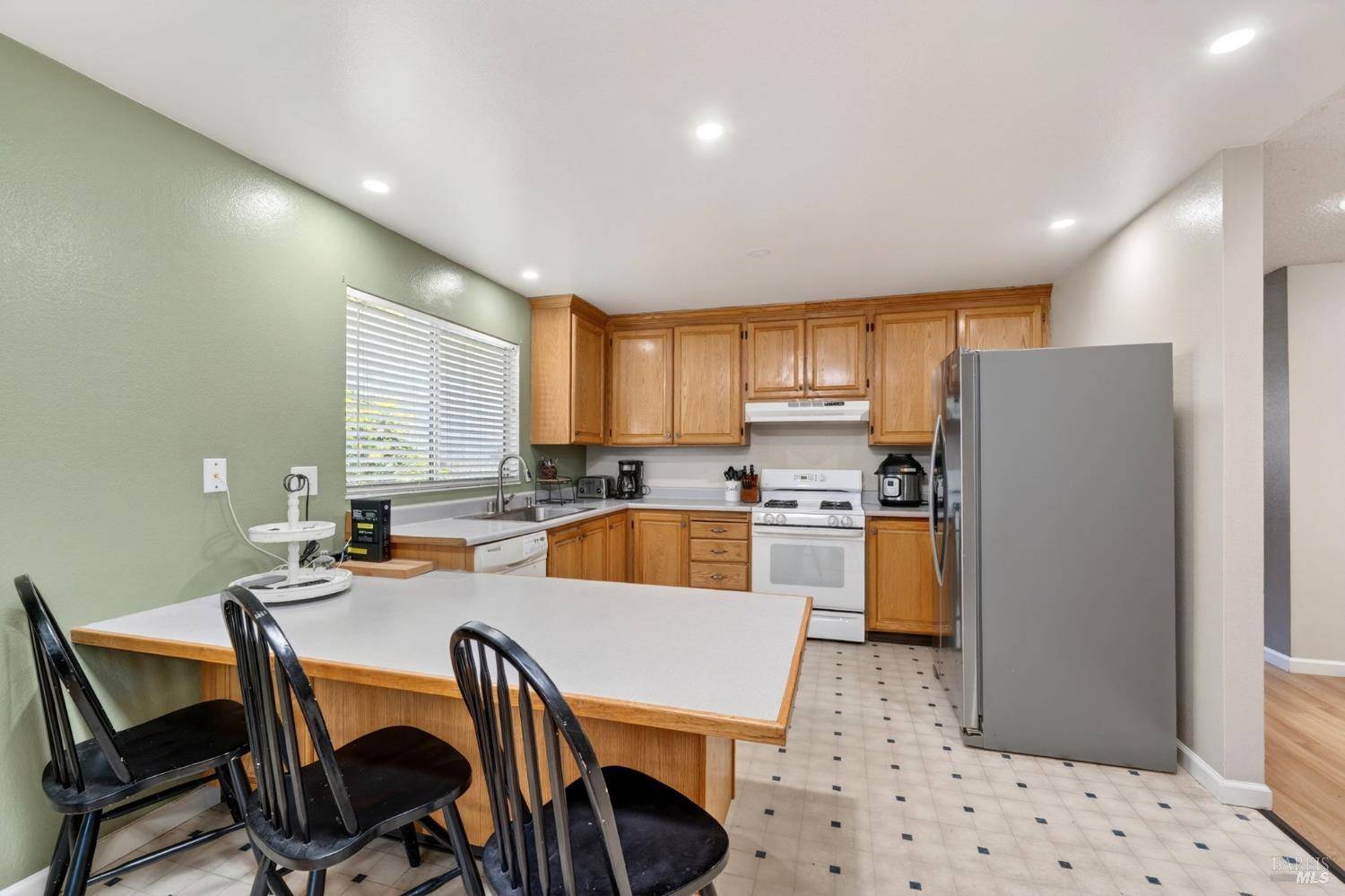 4526 Hillview Court Rohnert Park, CA 94928 - Photo 7 of 28 a kitchen with stainless steel appliances a refrigerator a sink a stove a dining table and chairs