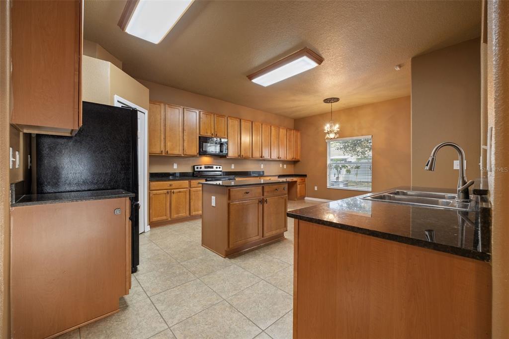 12112 Luftburrow Lane Hudson, FL 34669 - Photo 8 of 35 a kitchen with stainless steel appliances granite countertop a sink a stove and a refrigerator