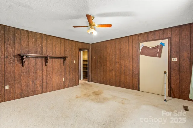 a view of a livingroom with a ceiling fan and refrigerator