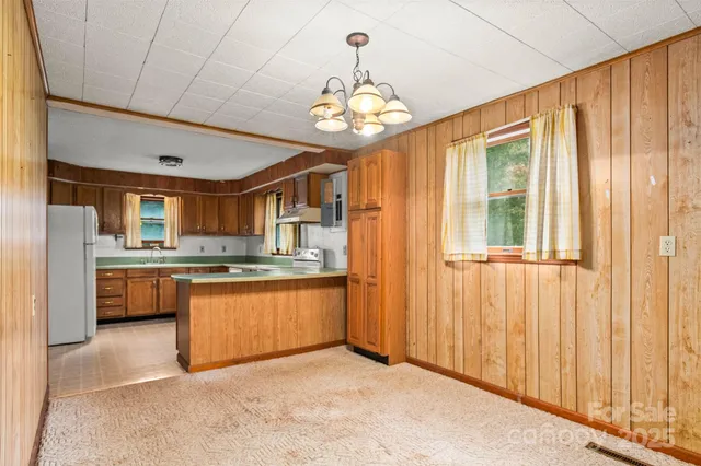 a view of a kitchen with granite countertop stainless steel appliances and a chandelier