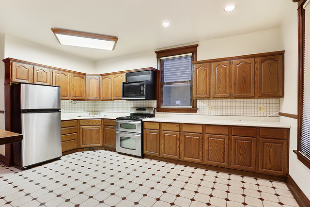 1745 West School Street Chicago, IL 60657 - Photo 3 of 12 a kitchen with granite countertop a refrigerator stove top oven and sink