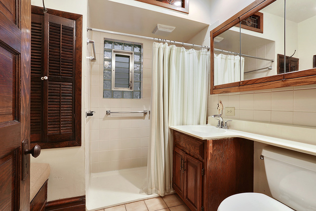 1745 West School Street Chicago, IL 60657 - Photo 4 of 12 a bathroom with a sink a toilet a mirror and shower