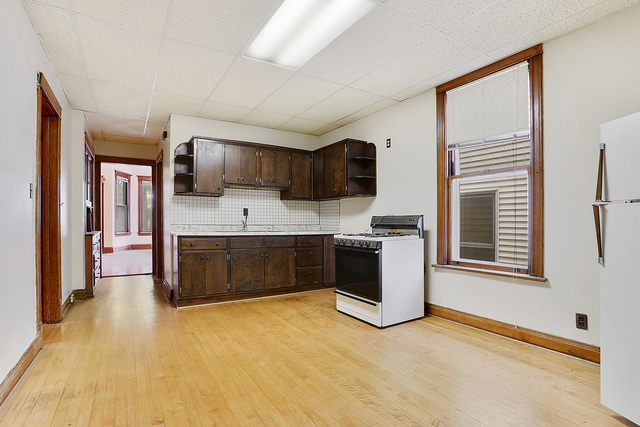 1745 West School Street Chicago, IL 60657 - Photo 7 of 12 a kitchen with stainless steel appliances a stove top oven and sink