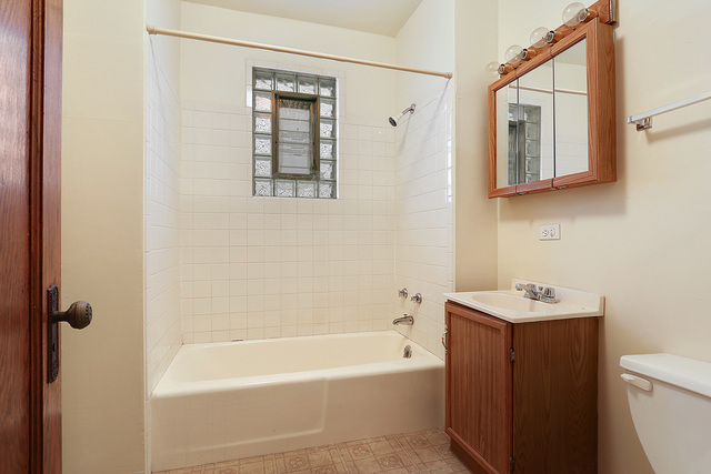 1745 West School Street Chicago, IL 60657 - Photo 8 of 12 a bathroom with a sink a toilet and shower