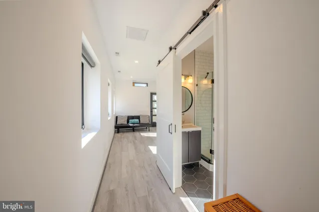 a view of a hallway with wooden floor and a living room