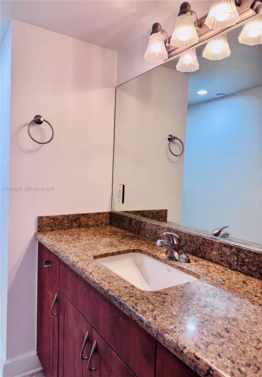 401 69th Street, Unit 607 Miami Beach, FL 33141 - Photo 58 of 89 a bathroom with a granite countertop sink and a mirror
