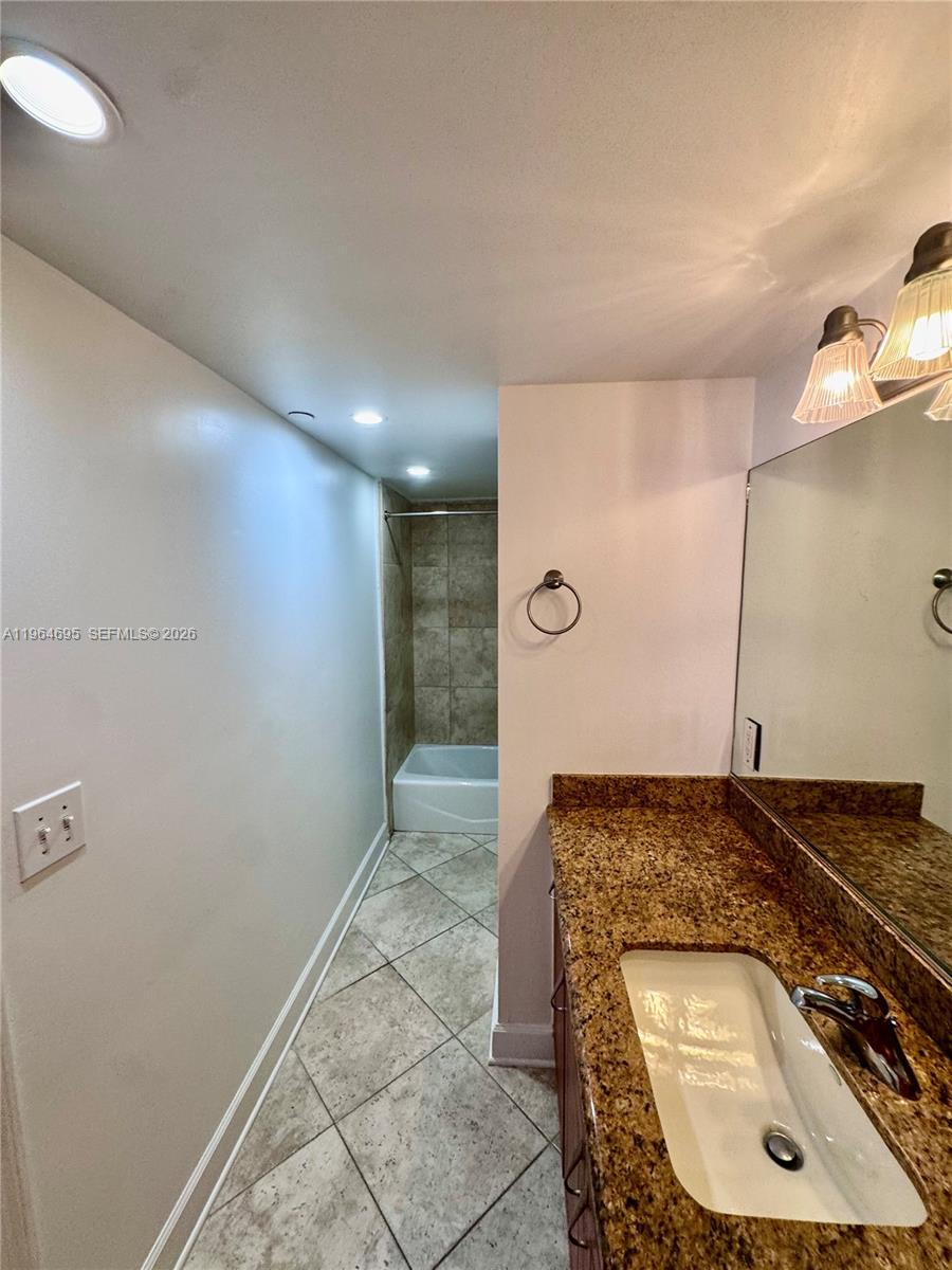 401 69th Street, Unit 607 Miami Beach, FL 33141 - Photo 61 of 89 a bathroom with a sink and a mirror