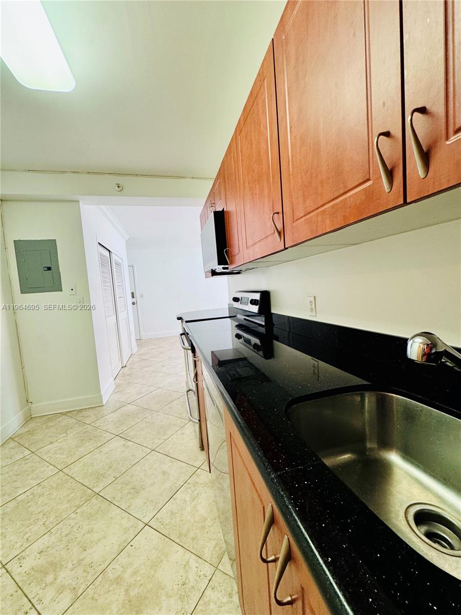 401 69th Street, Unit 607 Miami Beach, FL 33141 - Photo 73 of 89 a kitchen with granite countertop a sink a stove and cabinets