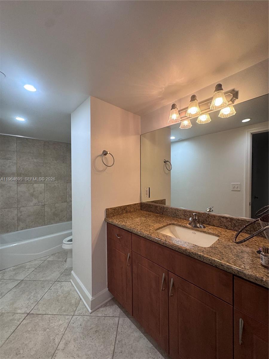 401 69th Street, Unit 607 Miami Beach, FL 33141 - Photo 81 of 89 a bathroom with a granite countertop sink and a mirror