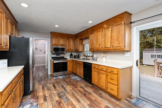 a kitchen with granite countertop stainless steel appliances cabinets a sink and a window