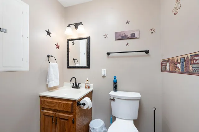 a bathroom with a sink a toilet and mirror