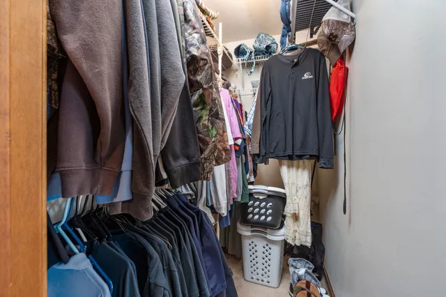 a view of walk in closet with clothes and shoes