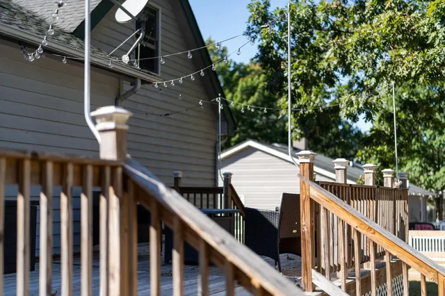 a view of a balcony with wooden stairs and fence