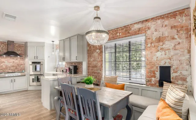 a dining room with furniture a chandelier and wooden floor