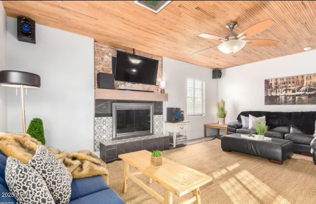 a living room with furniture a flat screen tv and a fireplace
