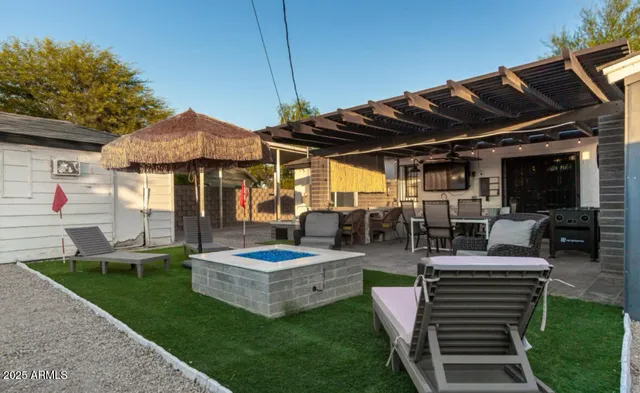 a view of a patio with table and chairs under an umbrella
