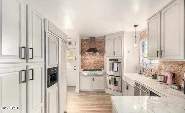 a kitchen with stainless steel appliances granite countertop a refrigerator and a sink