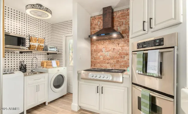 a kitchen with a stove and white cabinets