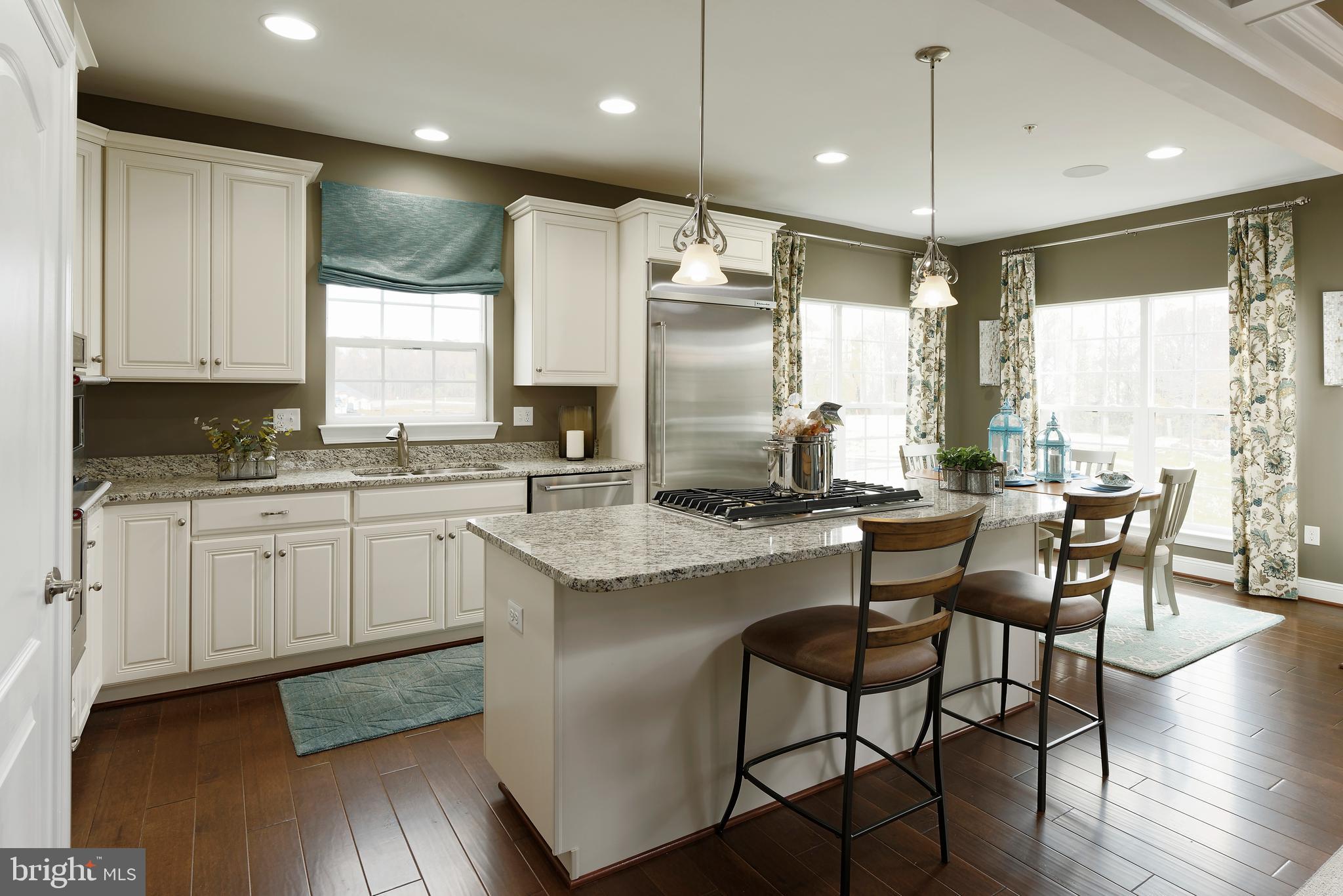 8600 Hines Circle Laurel, MD 20723 - Photo 2 of 9 a kitchen with stainless steel appliances granite countertop a stove a sink a microwave a dining table and chairs