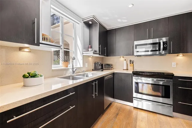 a kitchen with stainless steel appliances a sink and a microwave