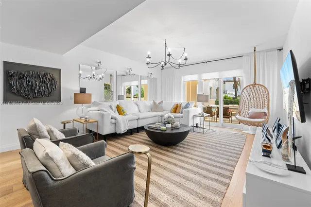a living room with furniture kitchen view and a chandelier