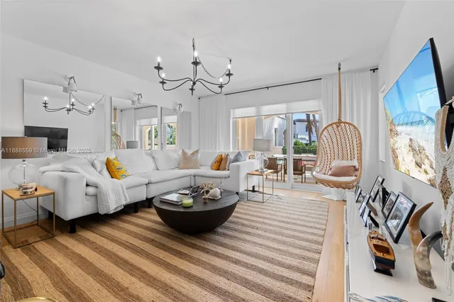 a living room with furniture chandelier and a fireplace