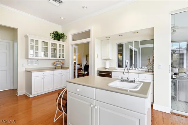 a kitchen with a sink cabinets and wooden floor