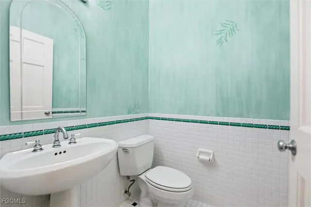 a bathroom with a sink a toilet and mirror
