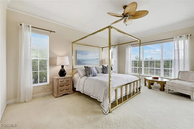 a spacious bedroom with a bed a chandelier and large window
