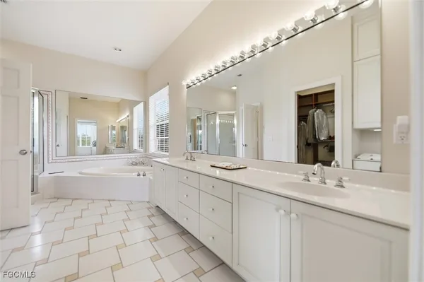 a bathroom with a granite countertop sink mirror and bathtub