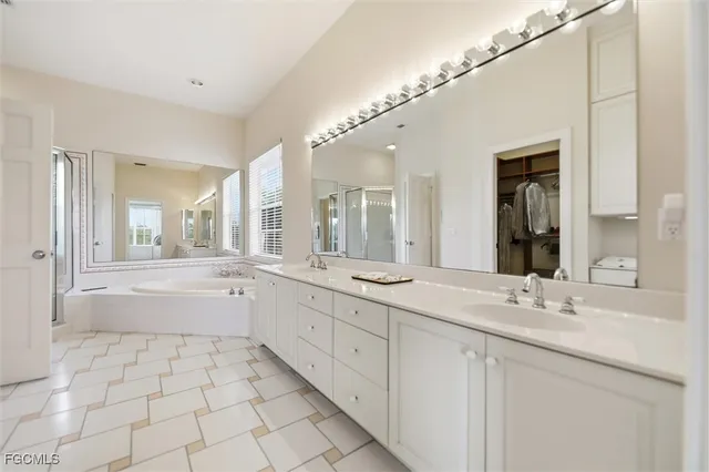 a bathroom with a granite countertop sink mirror and bathtub