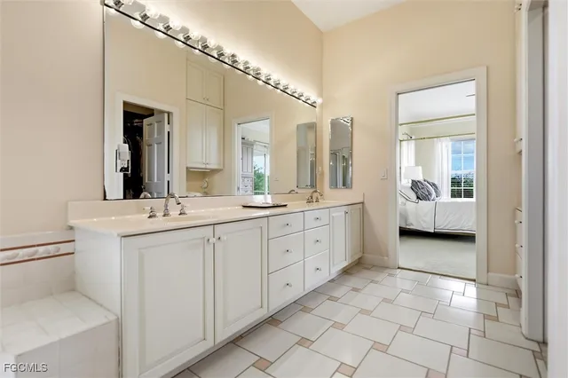 a spacious en suite bathroom with a double vanity sink and mirror
