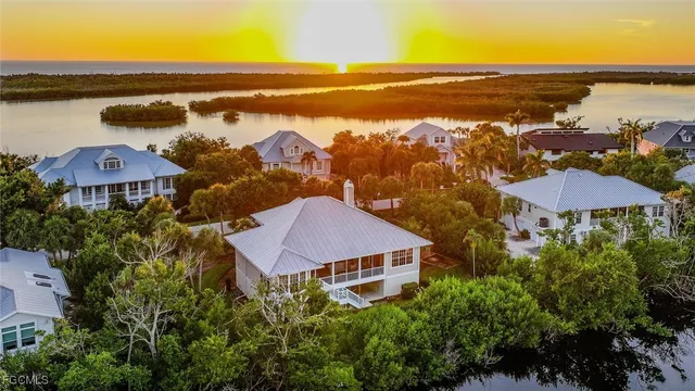 an aerial view of residential houses with outdoor space and ocean view