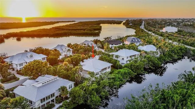 an aerial view of ocean and residential houses with outdoor space