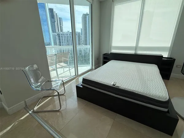 a bed sitting in a bedroom next to a window