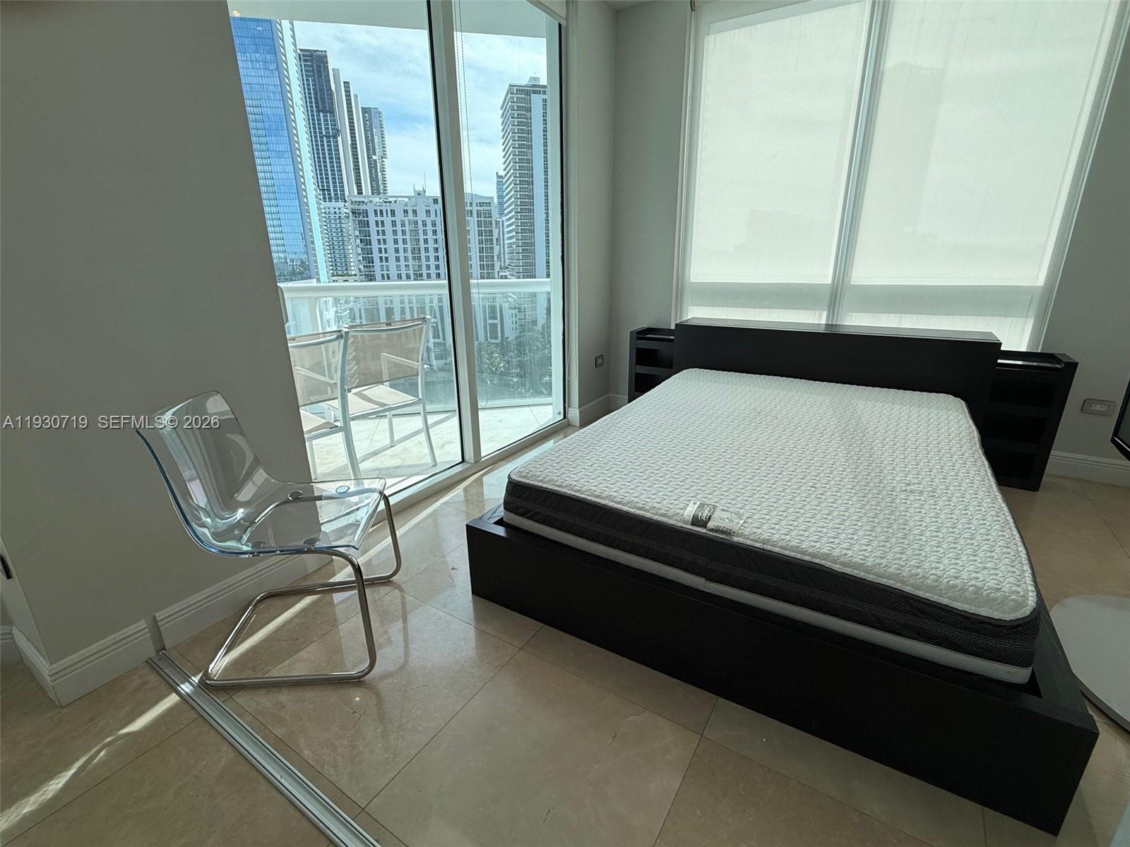 480 Northeast 30th Street, Unit 1505 Miami, FL 33137 - Photo 12 of 21 a bed sitting in a bedroom next to a window