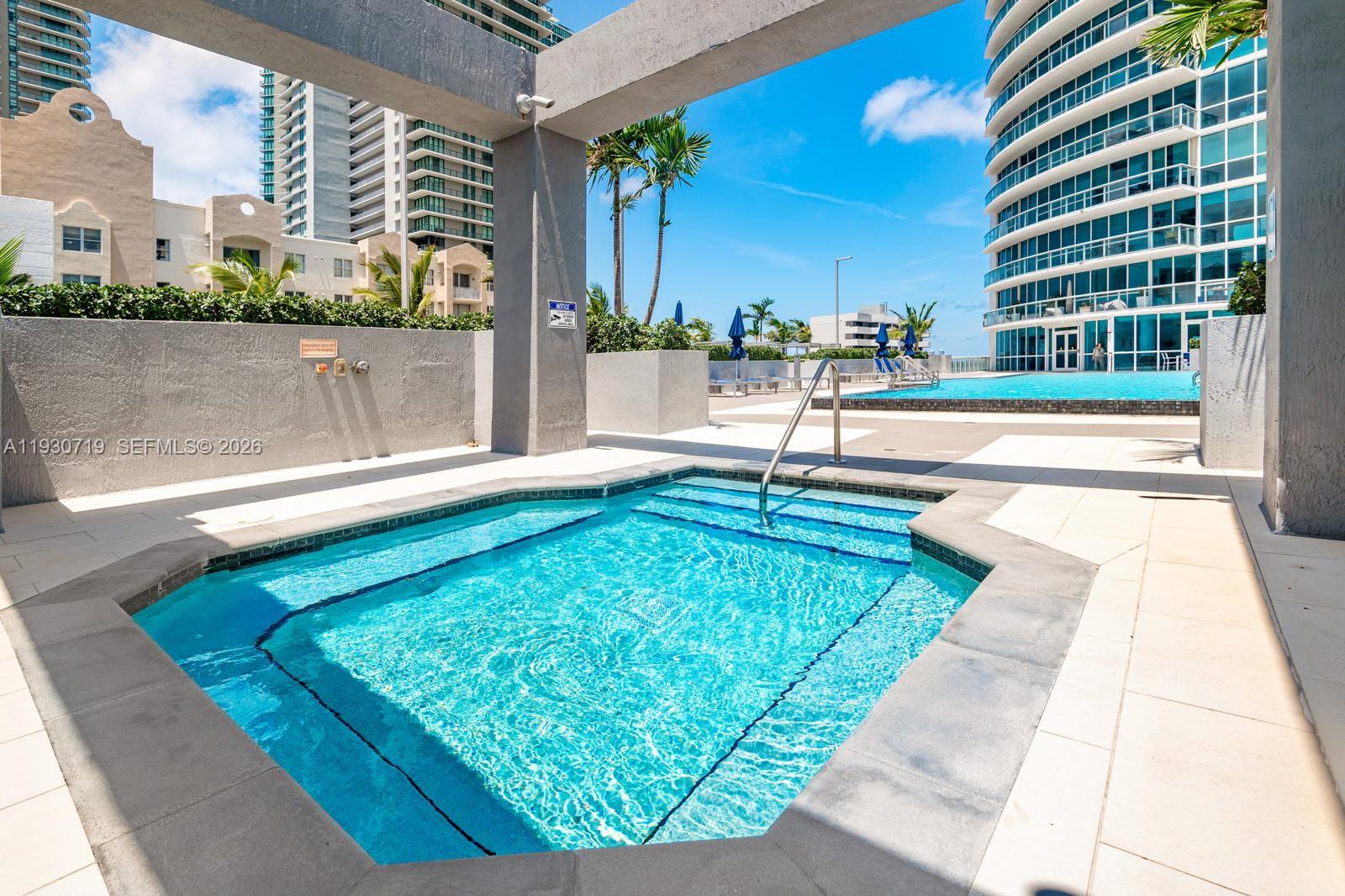 480 Northeast 30th Street, Unit 1505 Miami, FL 33137 - Photo 18 of 21 a swimming pool with outdoor seating and yard