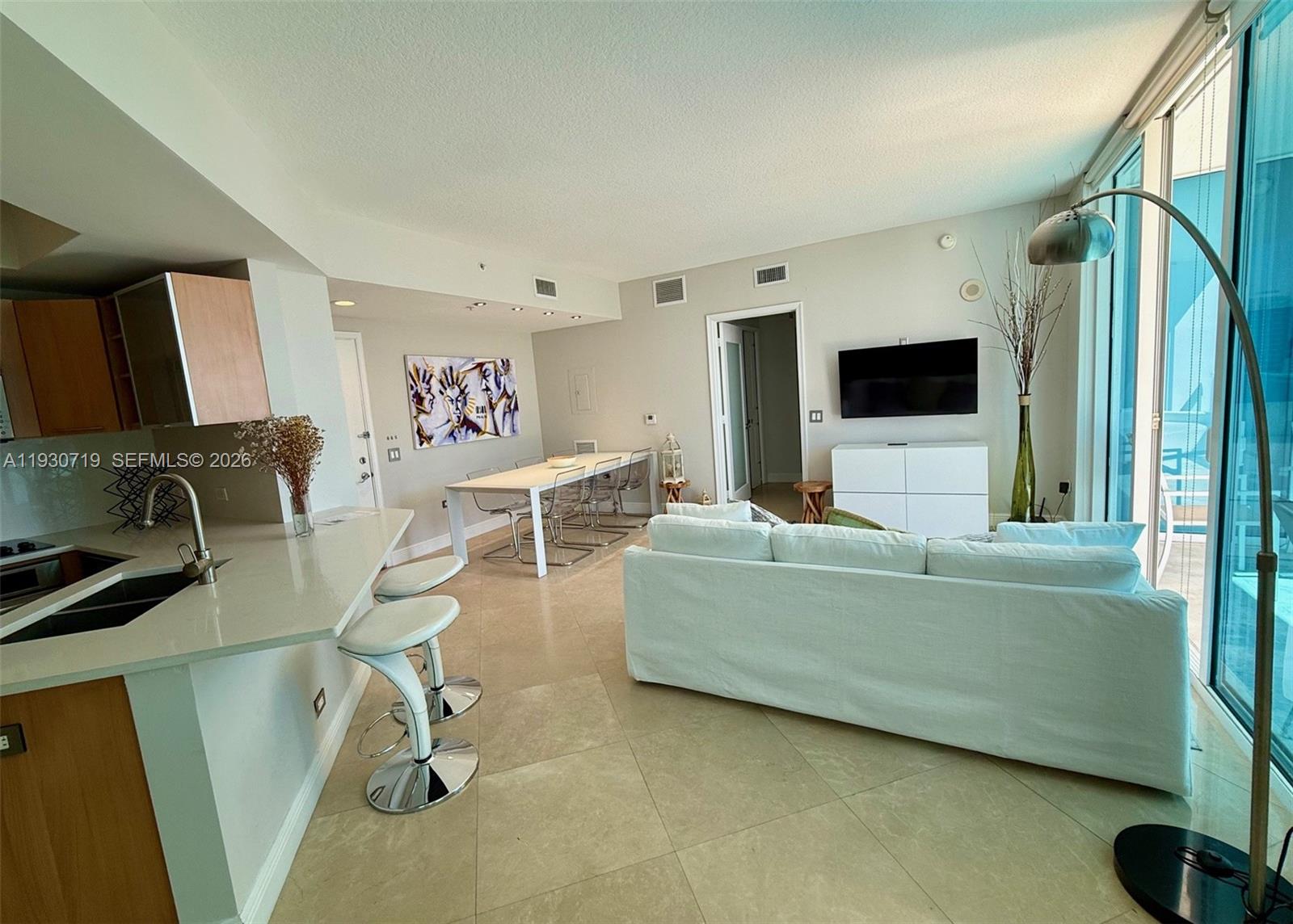 480 Northeast 30th Street, Unit 1505 Miami, FL 33137 - Photo 5 of 21 a living room with furniture and a flat screen tv